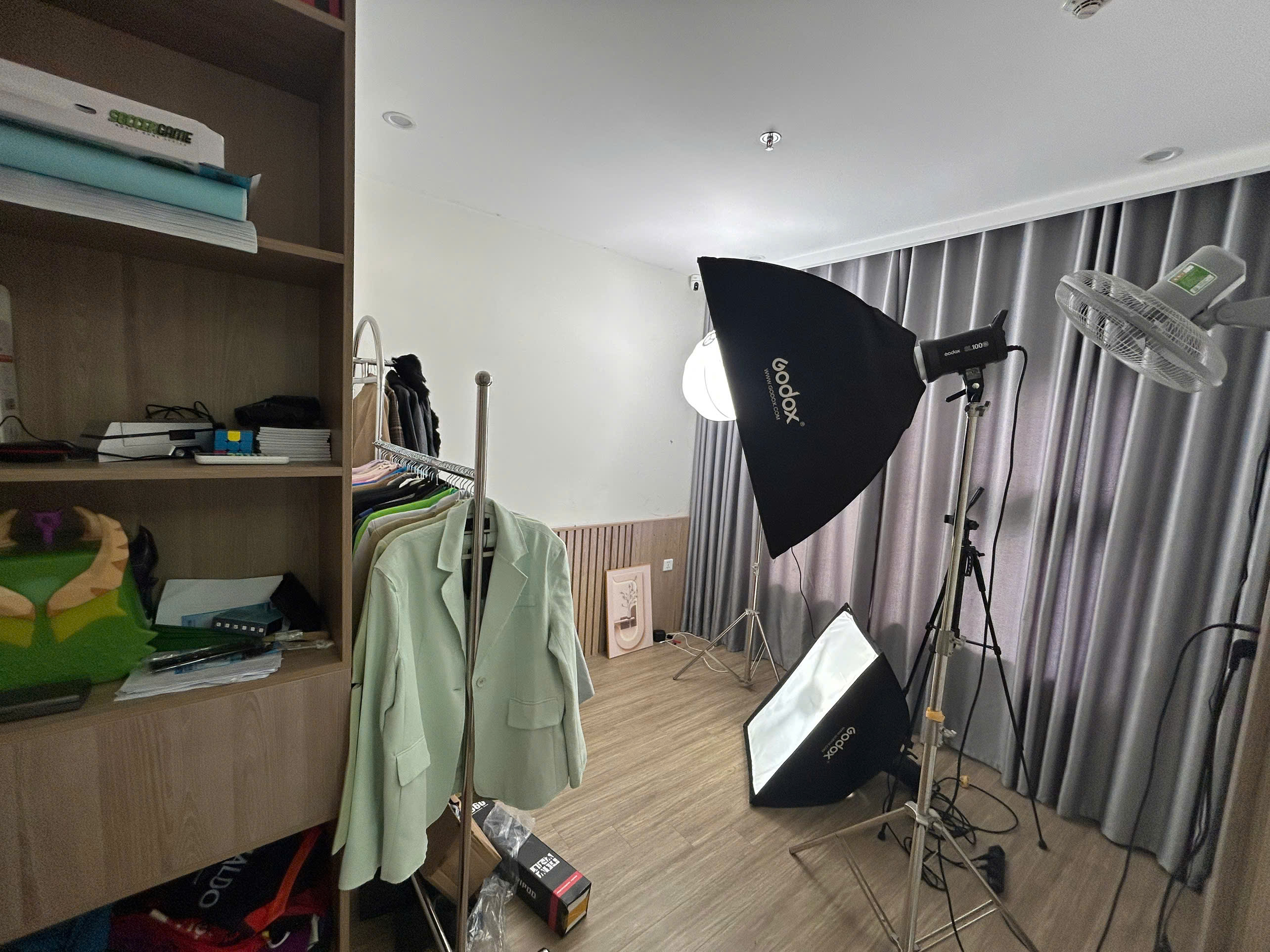 Không gian phòng livestream bán hàng được MyPC setup với hệ thống đèn Godox, softbox chuyên nghiệp, background rèm và khu vực trưng bày quần áo, giúp người bán lên hình sáng đẹp và sản phẩm hiển thị rõ nét.