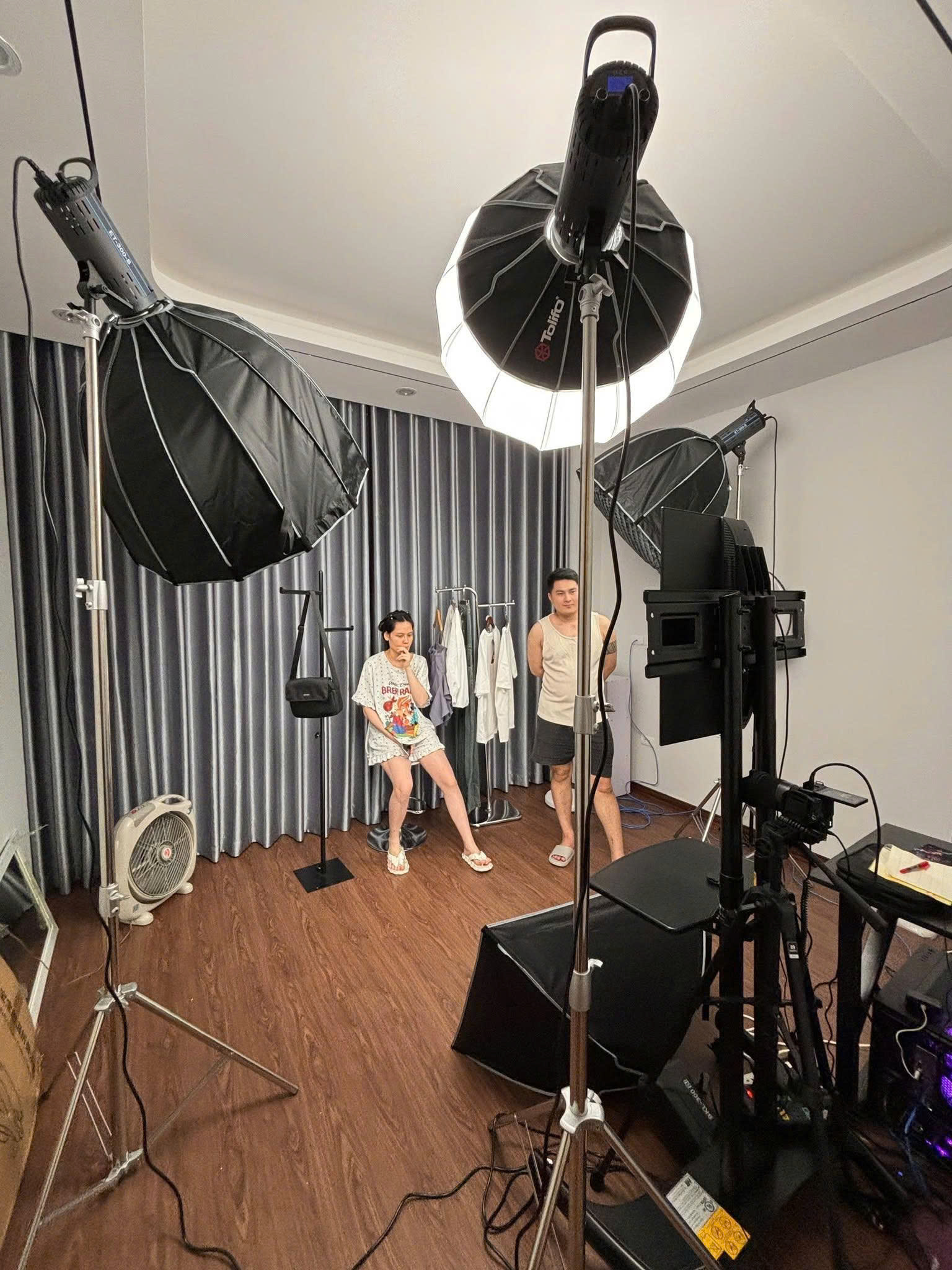 Phòng livestream thời trang được bố trí nhiều đèn studio, camera và màn hình theo dõi giúp khu vực người mẫu đủ sáng, sản phẩm lên hình rõ và thuận tiện khi bán hàng trực tiếp.